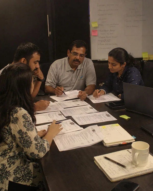 B2B Sales Recruitment Services Recruitment team reviewing candidate resumes and profiles for B2B sales roles during a meeting.