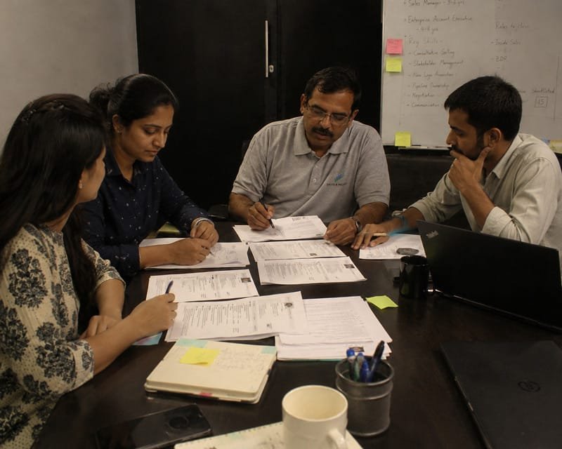 a team of sales recruiters going through multiple candidate profiles