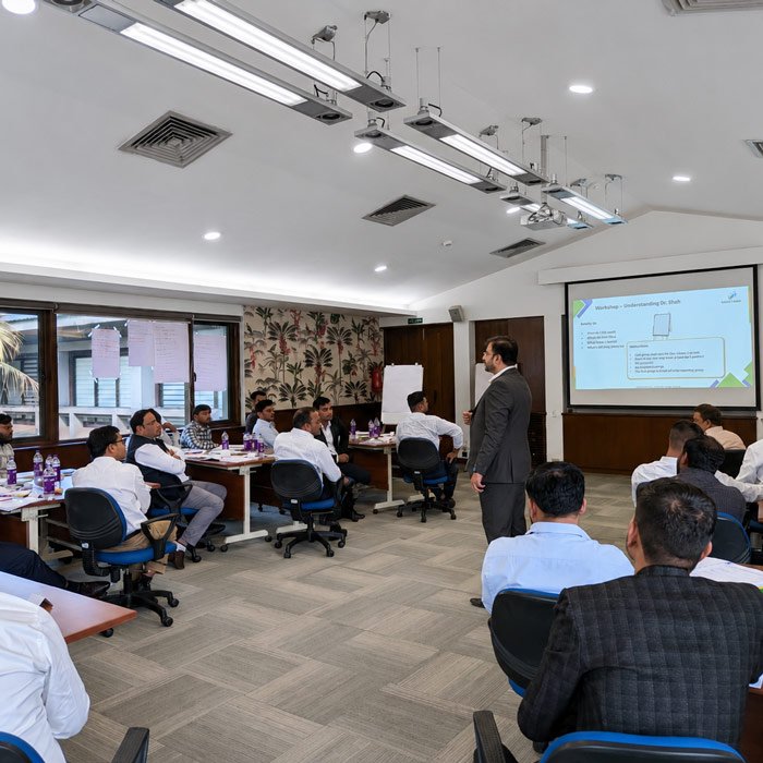 Advanced Corporate IT Sales Training Program A corporate IT sales training workshop with a trainer presenting to a group of executives.