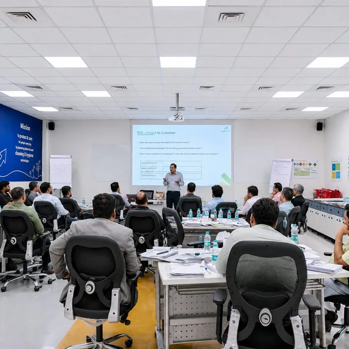 Corporate trainer presenting a customer ROI and value framework to a B2B sales team in India.